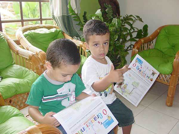 Crianças lendo O Brasileirinho, primeiro jornal do Brasil feito com a participação de crianças e jovens